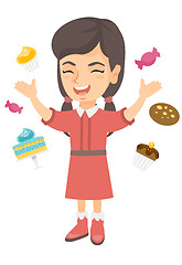 Image showing Happy caucasian girl standing among lots of sweets