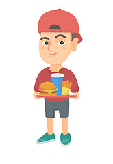Image showing Little caucasian boy holding tray with fast food.
