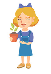 Image showing Caucasian smiling girl holding a potted plant.