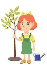 Image showing Caucasian smiling girl planting a tree.
