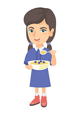 Image showing Happy girl holding a spoon and bowl of porridge.