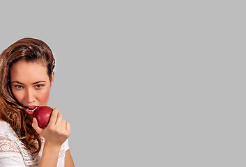 Image showing Woman eating a red apple