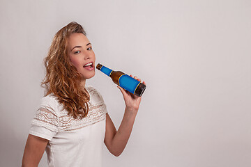 Image showing smiling woman drinks from a bottle