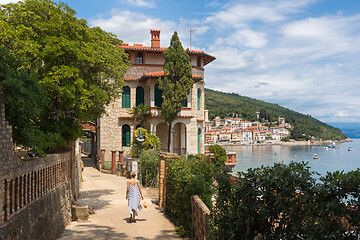 Image showing Female tourist walking along Adriatic sea coast relaxing on vacation in Moscenicka Draga, Istria, Croatia.