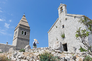 Image showing Female traveler sightseeing in an ancient costal village of Lubenice on the island of Cres, Croatia