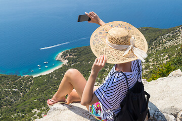 Image showing Active sporty woman on summer vacations taking selfie picture while enjoying beautiful coastal view of Cres island, Croatia from Lubenice traditional costal village