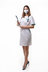 Image showing model in medical uniform with medical attributes and a tablet on a white background