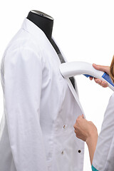 Image showing steaming medical clothing on a manicure on a white background