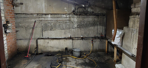 Image showing Basement renovation process. Dark dirty room with pipes