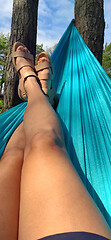 Image showing Crossed legs of a woman lying on a hammock in the woods