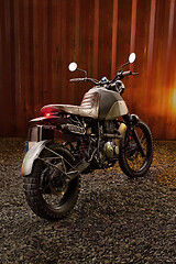 Image showing Custom scrambler motorbike on a rusty container background.