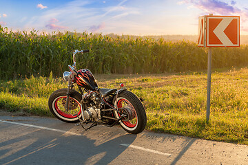 Image showing Custom bobber motorbike standing on a road.