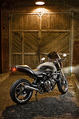 Image showing Custom caferacer motorbike on an old garage door background.