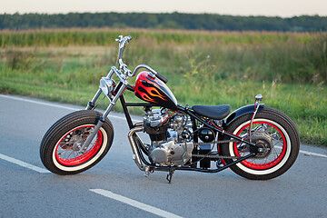 Image showing Custom bobber motorbike standing on a road.