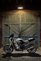 Image showing Custom caferacer motorbike on an old garage door background.