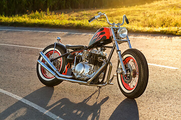 Image showing Custom bobber motorbike standing on a road.