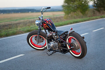 Image showing Custom bobber motorbike standing on a road.