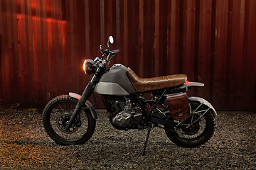 Image showing Custom scrambler motorbike on a rusty container background.