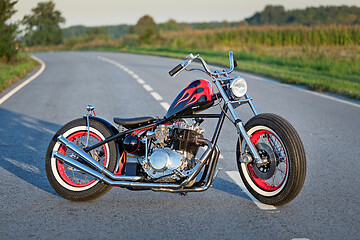 Image showing Custom bobber motorbike standing on a road.