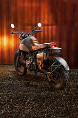 Image showing Custom scrambler motorbike on a rusty container background.