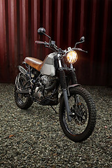 Image showing Custom scrambler motorbike on a rusty container background.
