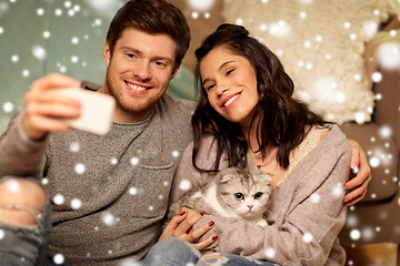 Image showing happy couple taking selfie by smartphone at home