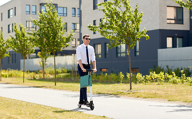 Image showing businessman with shopping bag riding scooter