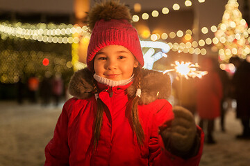 Image showing happy girl with sparkler at christmas market