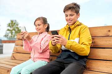 Image showing children with smartphones sitting on street bench