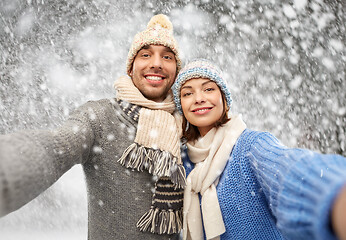 Image showing happy couple in winter clothes taking selfie