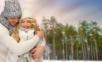 Image showing couple hugging over winter forest background