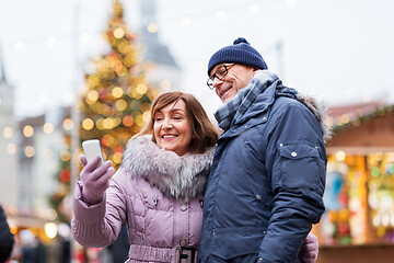 Image showing senior couple taking selfie at christmas market