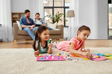 Image showing happy sisters doing arts and crafts at home