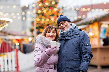 Image showing senior couple taking selfie at christmas market