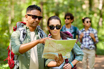 Image showing friends with map and backpacks hiking in forest