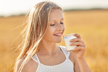 Image showing girl drinking milk from glass on cereal field