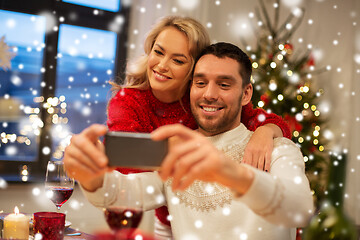Image showing happy couple taking selfie at christmas dinner