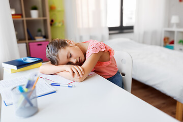 Image showing tired student girl sleeping on table at home