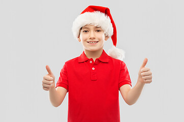 Image showing smiling boy in santa helper hat showing thumbs up