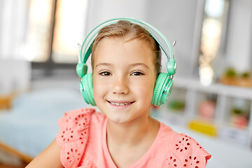 Image showing girl in headphones listening to music at home