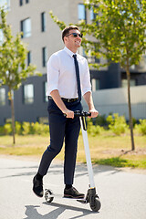 Image showing young businessman riding electric scooter outdoors