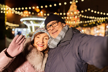 Image showing senior couple taking selfie at christmas market