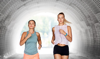 Image showing women or female friends with earphones running