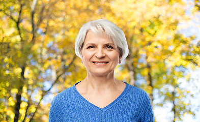 Image showing portrait of smiling senior woman in autumn park