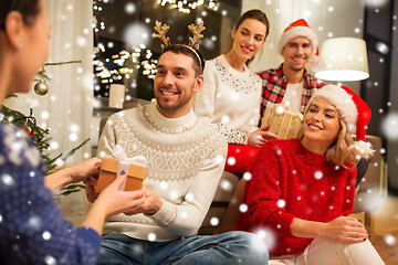 Image showing friends celebrating christmas and giving presents