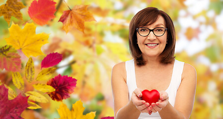 Image showing portrait of smiling senior woman holding red heart