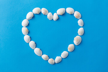 Image showing sea shells in shape of heart on blue background