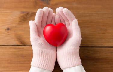 Image showing hands in pink woollen gloves holding red heart