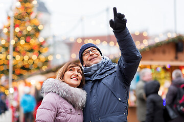 Image showing happy senior couple hugging at christmas market