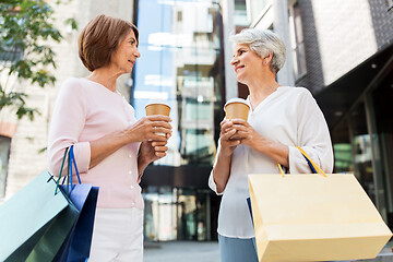 Image showing senior women with shopping bags and coffee in city